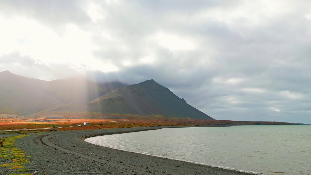 在冰岛的海岸线上，阳光穿过云层到达顶峰视频素材