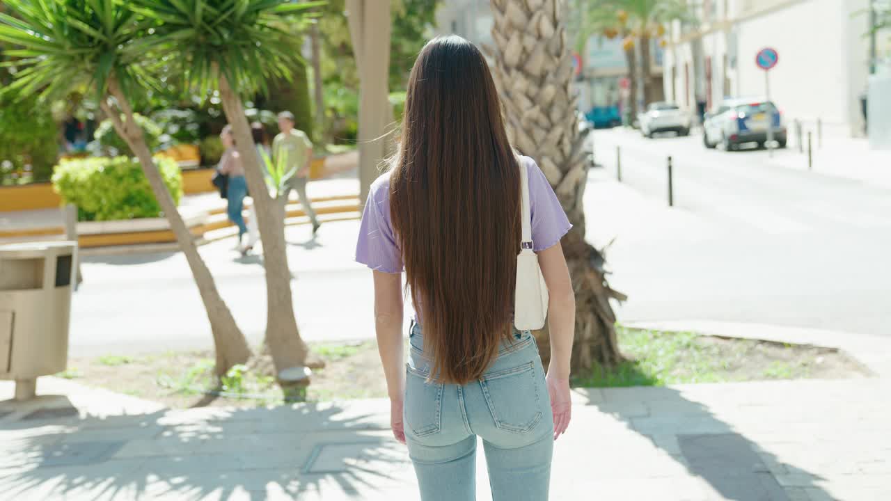 年轻美丽的西班牙女子站在街道与双臂交叉手势视频素材