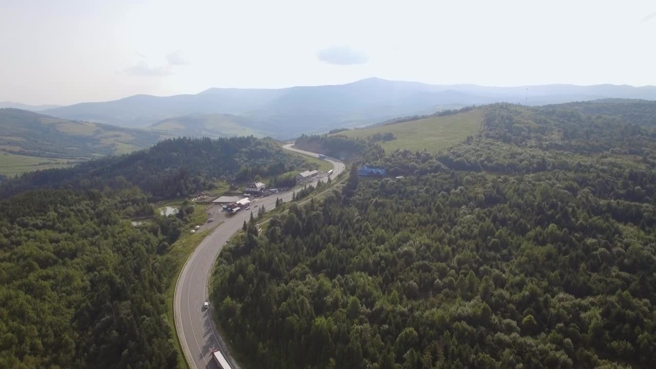 无人机航拍图:在阳光明媚的日子里飞越松树林和乡村道路视频素材