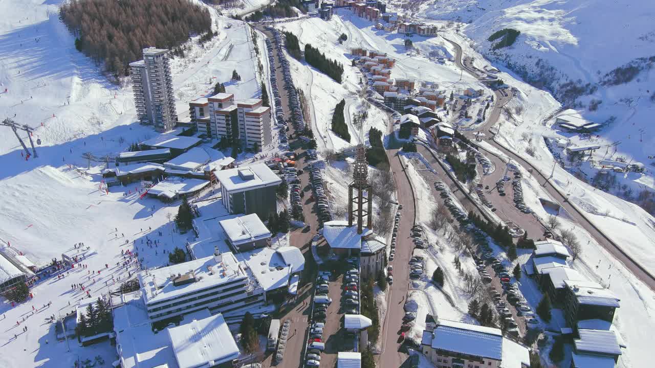 法国，Les Menuires:法国著名的阿尔卑斯山滑雪胜地(萨瓦阿尔卑斯山)冬季鸟瞰，阳光明媚，雪景丰富——从高处俯瞰欧洲全景视频素材