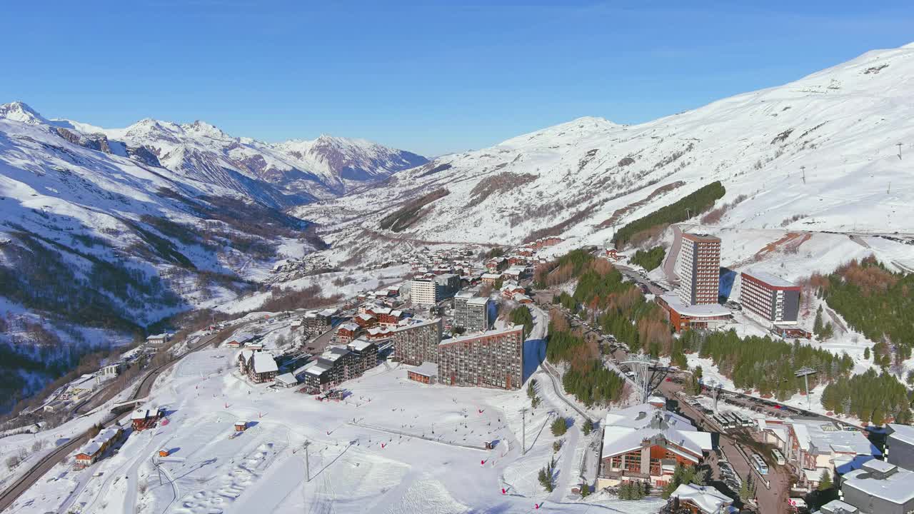 法国，Les Menuires:法国著名的阿尔卑斯山滑雪胜地(萨瓦阿尔卑斯山)冬季鸟瞰，阳光明媚，雪景丰富——从高处俯瞰欧洲全景视频素材