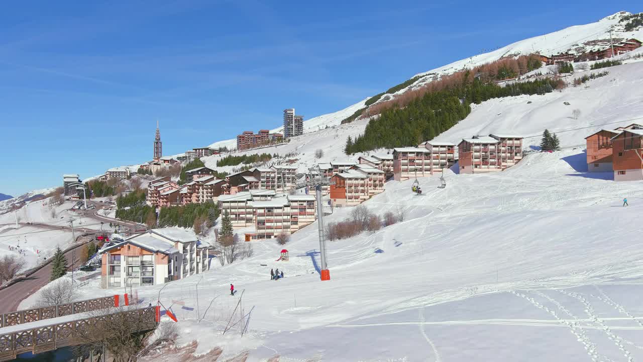 法国，Les Menuires:法国著名的阿尔卑斯山滑雪胜地(萨瓦阿尔卑斯山)冬季鸟瞰，阳光明媚，雪景丰富——从高处俯瞰欧洲全景视频素材