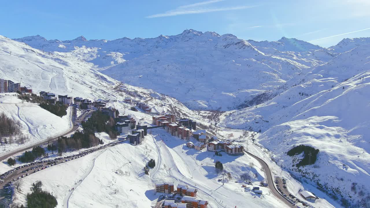 法国，Les Menuires:法国著名的阿尔卑斯山滑雪胜地(萨瓦阿尔卑斯山)冬季鸟瞰，阳光明媚，雪景丰富——从高处俯瞰欧洲全景视频素材