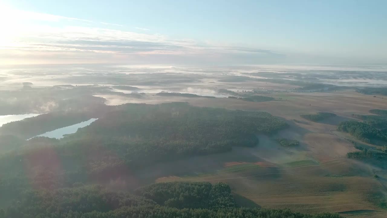 雾蒙蒙的早晨，在森林和田野环绕的美丽湖泊上。一个小村庄，坐落在雾和晨曦中湖附近。视频素材