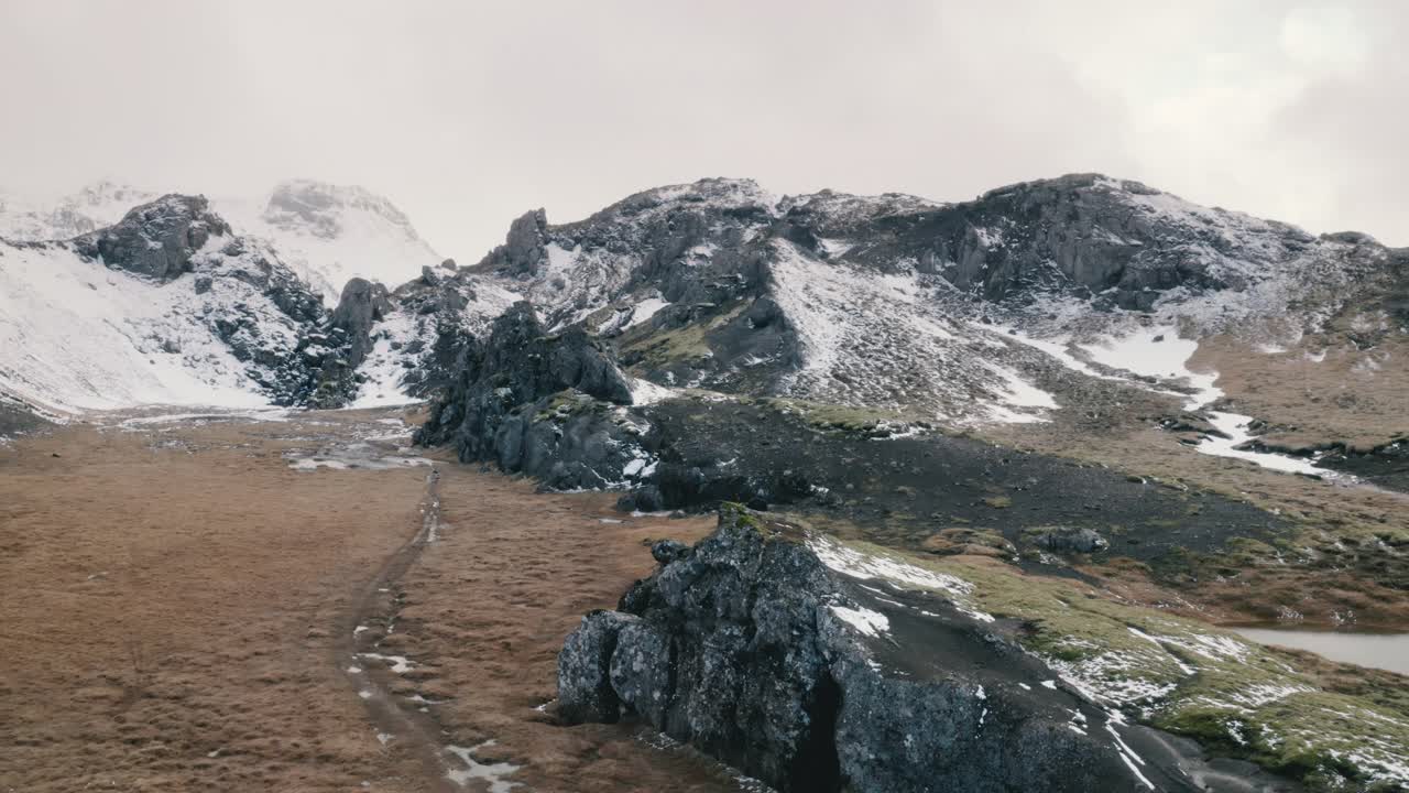 冰岛雪山景观与摄影师步行无人机视图视频素材