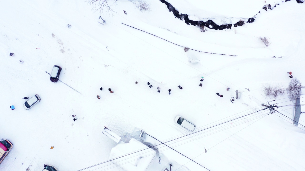 4K鸟瞰图，大雪天在小镇旅游的人们。视频素材