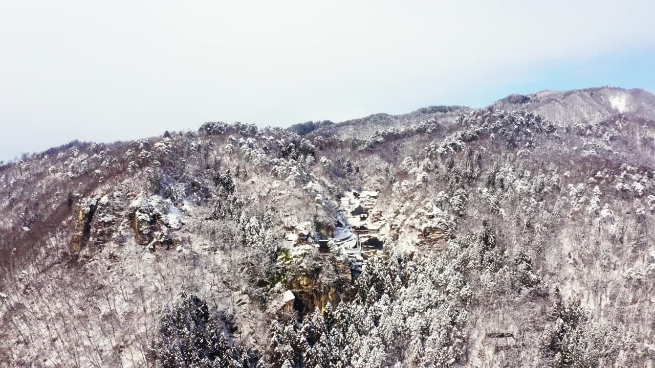 4K雪天山上小村庄或寺庙鸟瞰图。视频素材