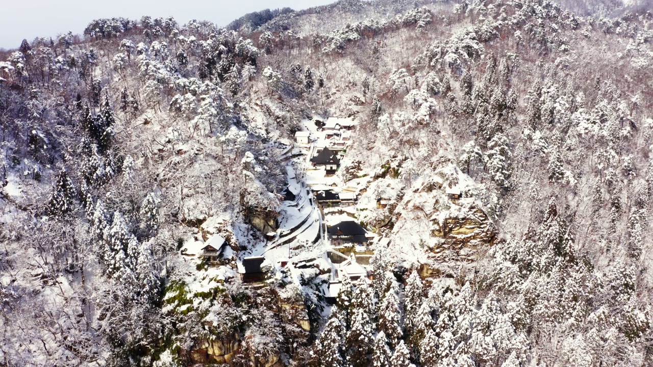 4K雪天山上小村庄或寺庙鸟瞰图。视频素材