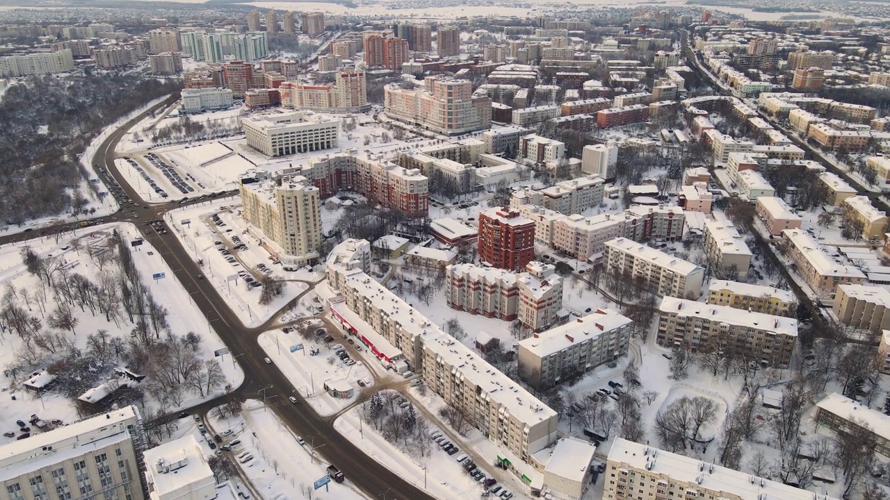 冬季城市积雪覆盖的居民区鸟瞰图。视频下载