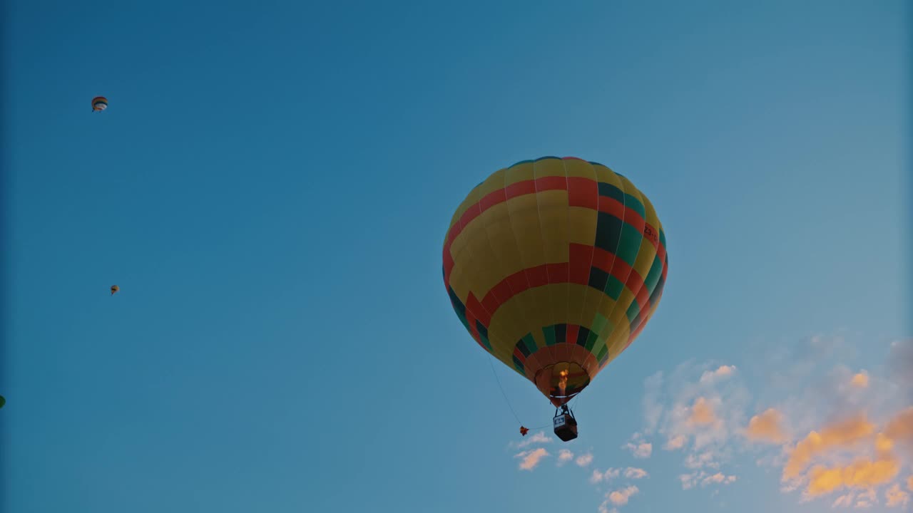 黄色的热气球漂浮在宁静的蓝天上视频素材