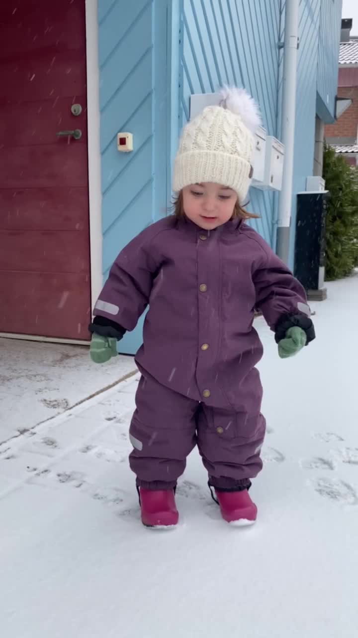 蹒跚学步的孩子第一次在雪中玩耍视频下载