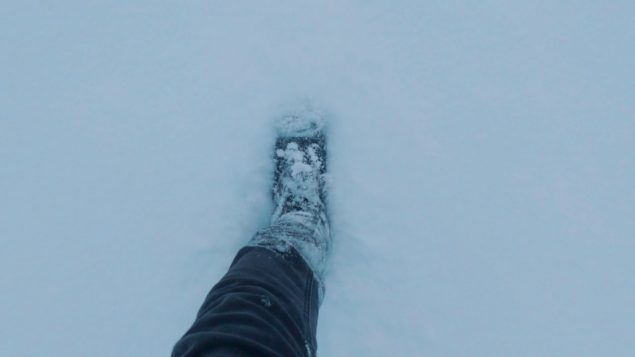 雪中的人类脚印。跟随白雪上的足迹。冬天的季节。雪地上行走的女人的腿和雪天的脚印穿着冬靴在雪地上行走。视频素材