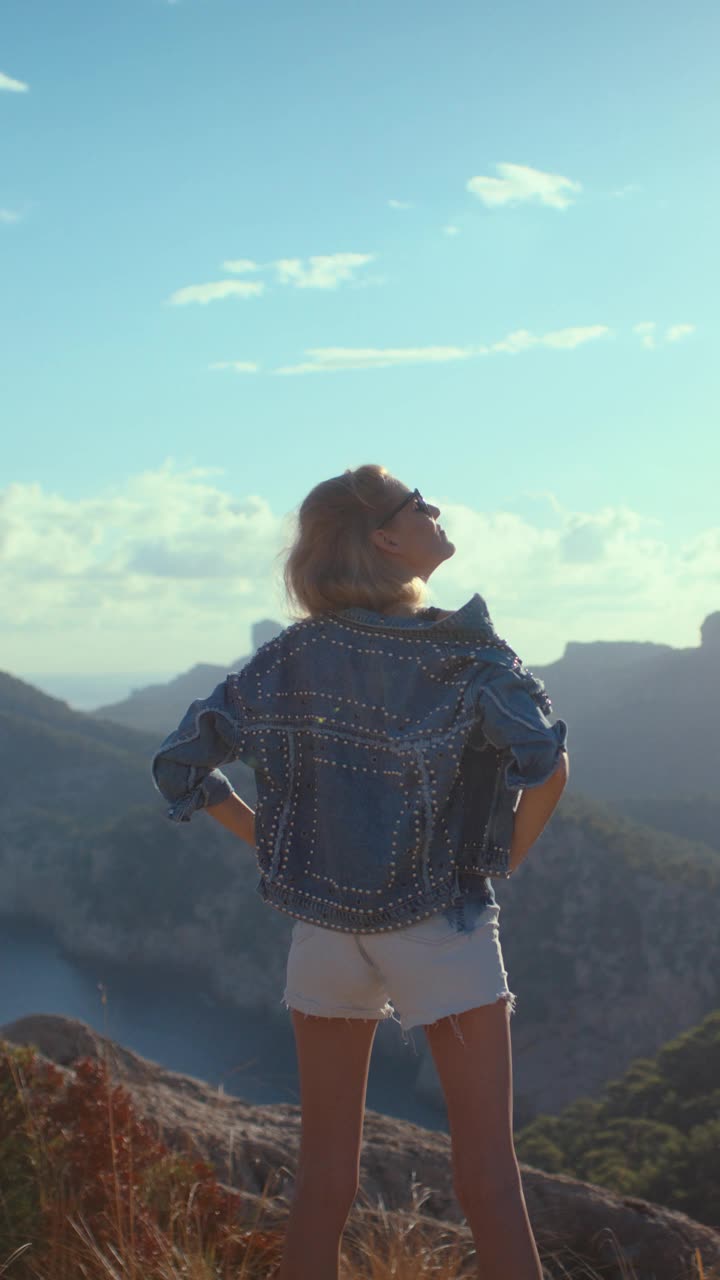 征服群山的特写镜头。女子在山顶手举起来庆祝徒步旅行垂直视频的结束视频素材