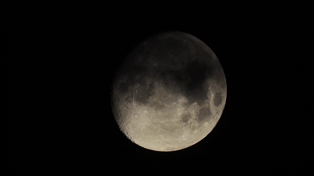 满月前的月亮在夜空的黑色背景上特写。云经过月亮视频素材