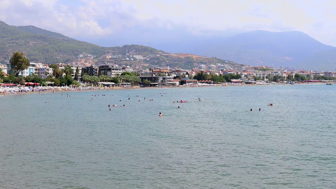 在土耳其安塔利亚美丽的海滩上，人们在夏天的时候在海滩上放松和玩耍，拍摄的4k镜头。视频素材