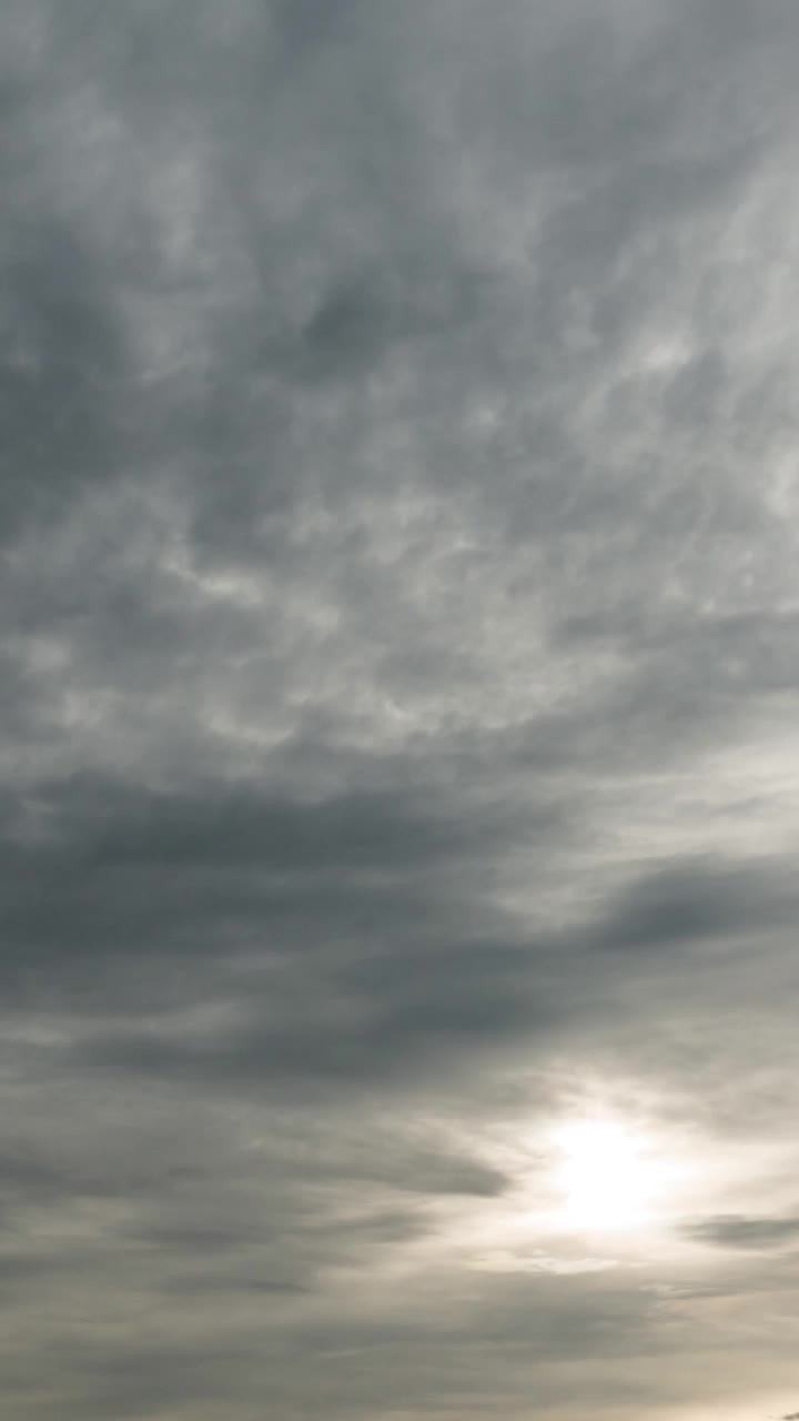 垂直视频的阴天与太阳通过暴风雨的云视频素材