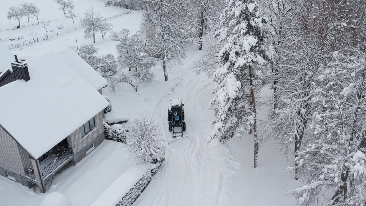 蓝色的拖拉机在清理院子里的积雪视频下载