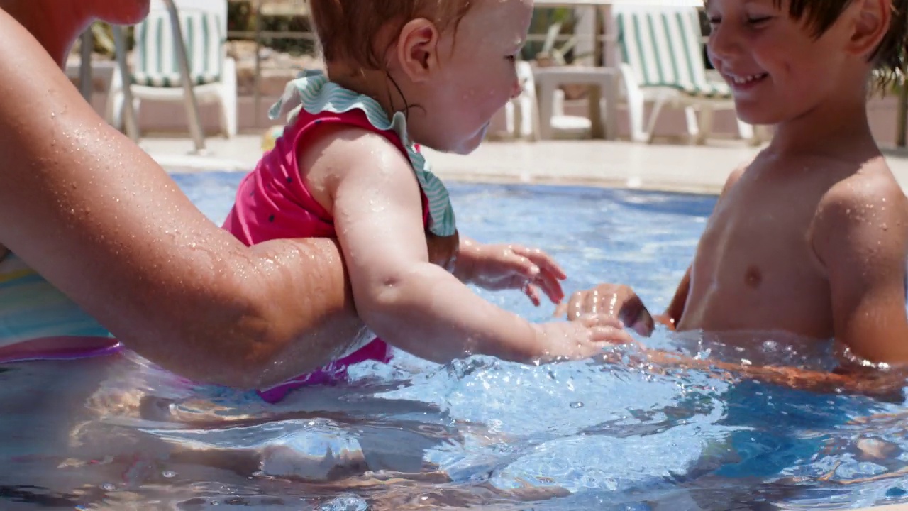 暑假期间，一家人在酒店游泳池里玩耍视频素材