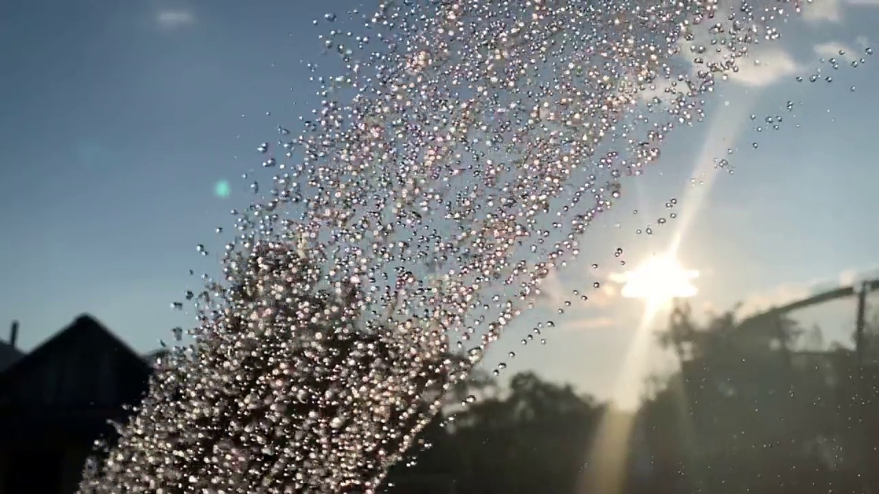 雄伟的视频动画裁剪的水淋浴雨流从洒水车，空气喷雾器，粉碎机对树木和天空视频素材