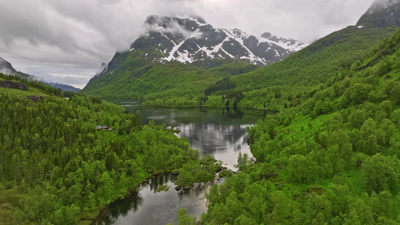 Hinnøya Island Norwegian v2低空飞越鹳形网湖捕捉清澈的水面，天空反射在水面上，周围环绕着森林和山景-与Mavic 3 Cine拍摄-2022年6月视频素材