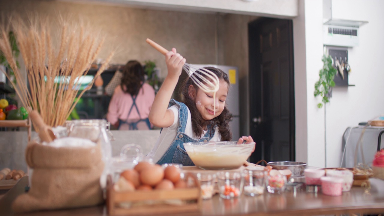 女孩们喜欢在碗里搅拌面团。视频素材