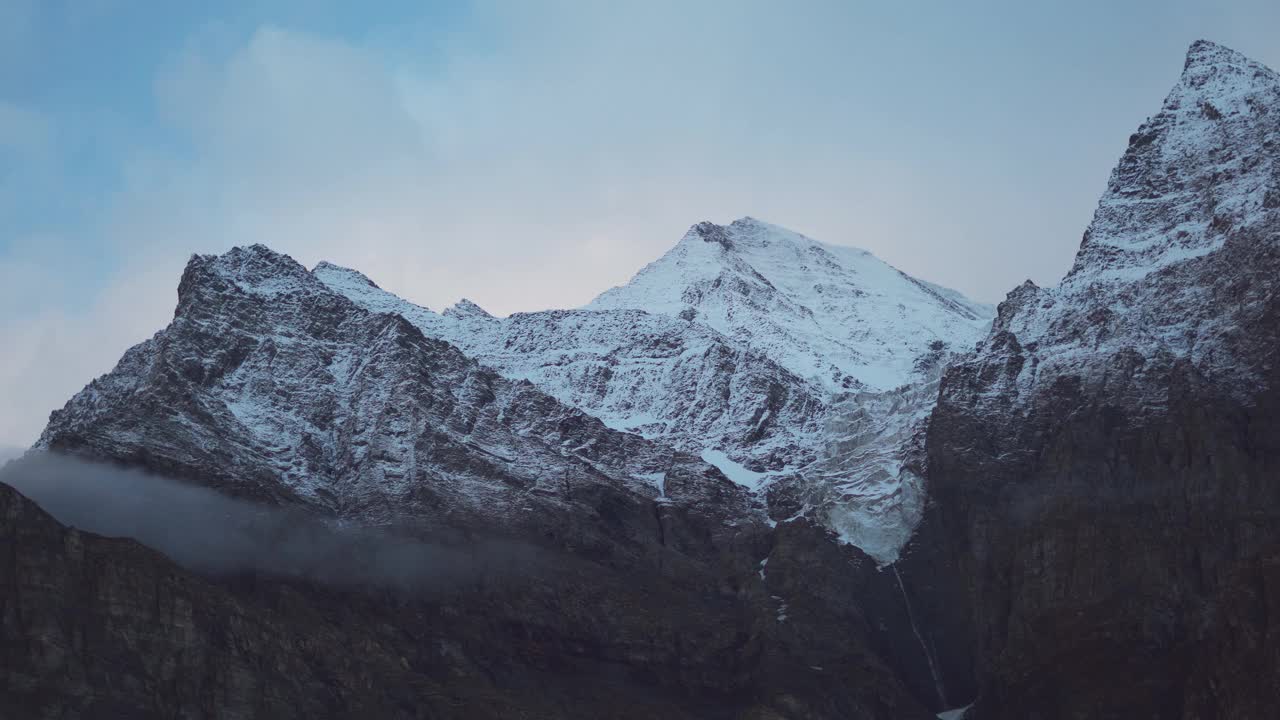 4K在印度喜马偕尔邦拉胡尔斯皮提地区的Keylong看到的白雪覆盖的山峰上的云的延时。白云飘过白雪覆盖的山峰。视频素材