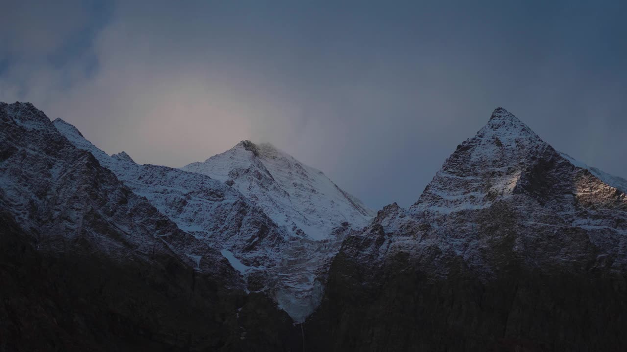 4K在印度喜马偕尔邦拉胡尔斯皮提地区的Keylong看到的白雪覆盖的山峰上的云的延时。白云飘过白雪覆盖的山峰。视频素材