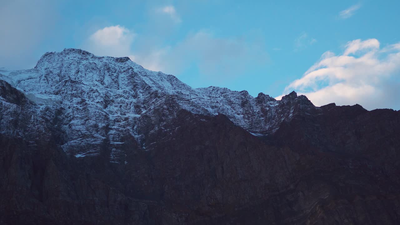 4K在印度喜马偕尔邦拉胡尔斯皮提地区的Keylong看到的白雪覆盖的山峰上的云的延时。白云飘过白雪覆盖的山峰。视频素材