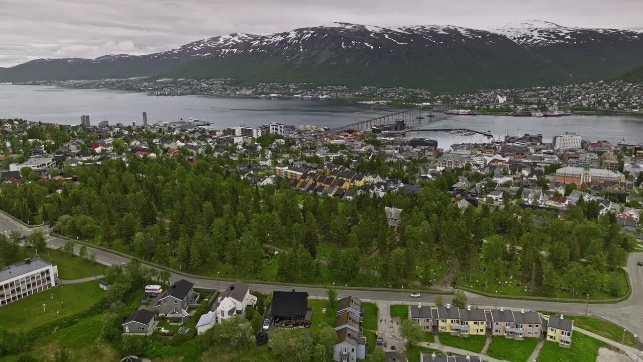 Tromsø Norway Aerial v7 low level flyover cemetery across residential neighborhood towards downtown, overlooking at mountain landscape across tromsøysundet strait - Shot with Mavic 3 Cine - June 2022视频素材