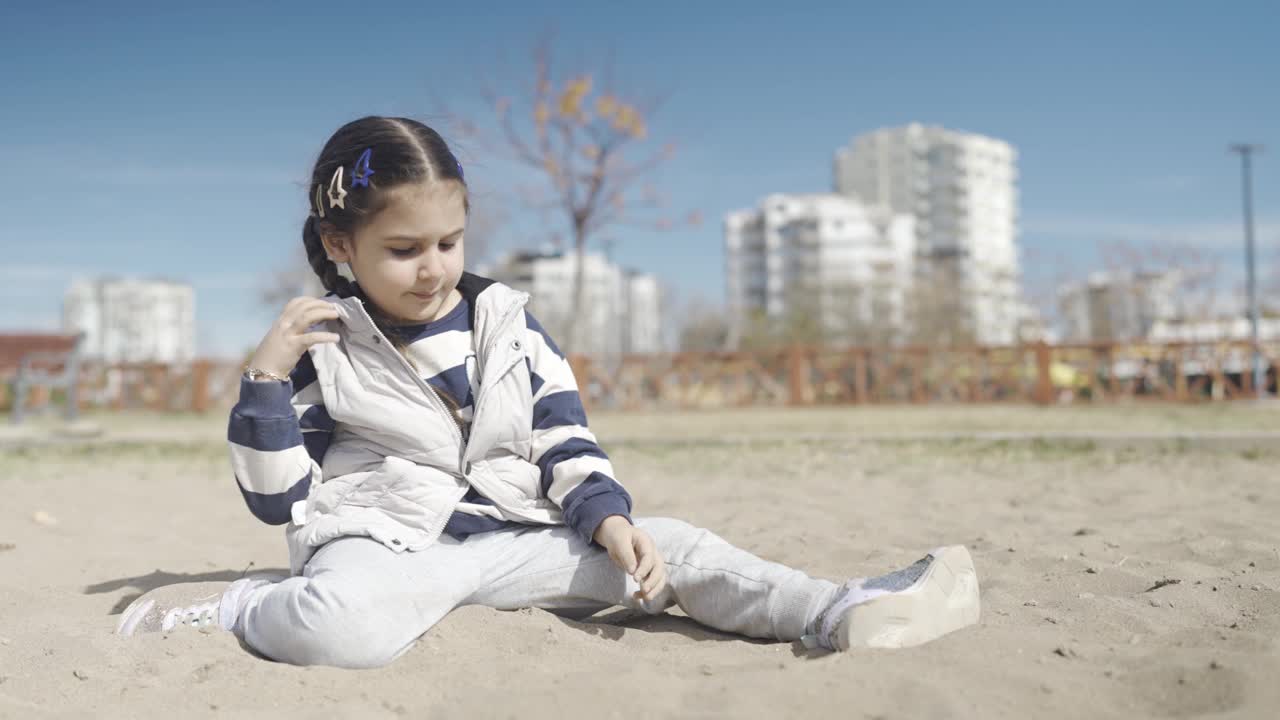 小女孩在操场上玩沙子视频素材