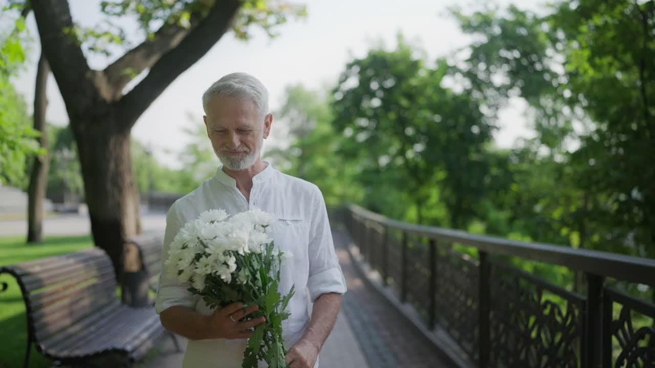 老年夫妇在公园见面，男人送花给女人，浪漫的约会视频素材