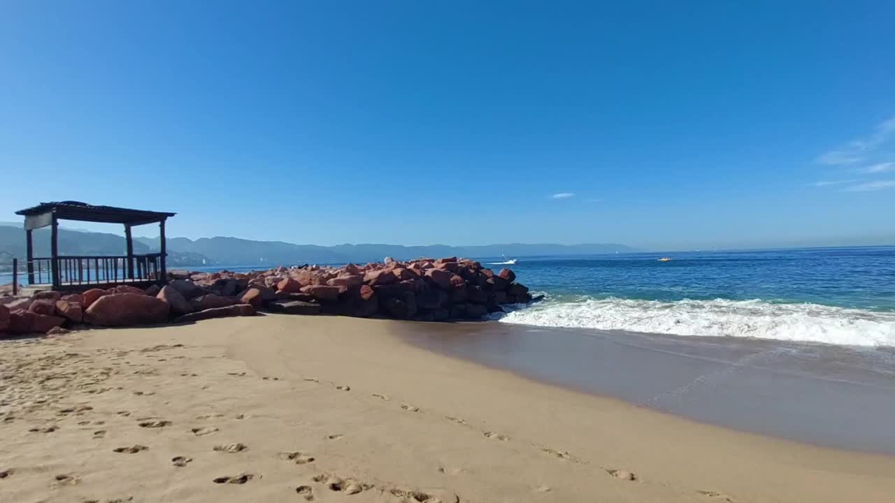 在阳光明媚的日子里，沙滩上有海浪和沙子的美丽景色视频素材