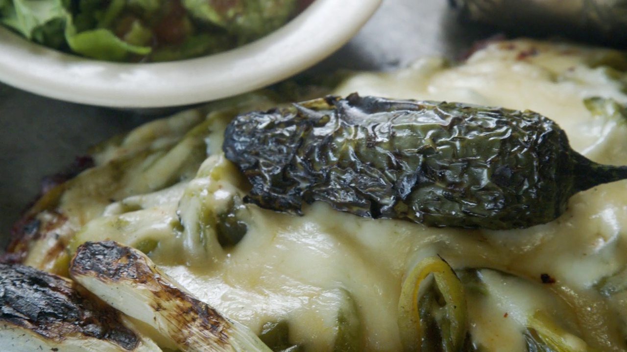 Mexican Flank Steak Grilled with Onion and Jalapeño Pepper and Melted Cheese in a Mexican Restaurant in Tijuana视频素材