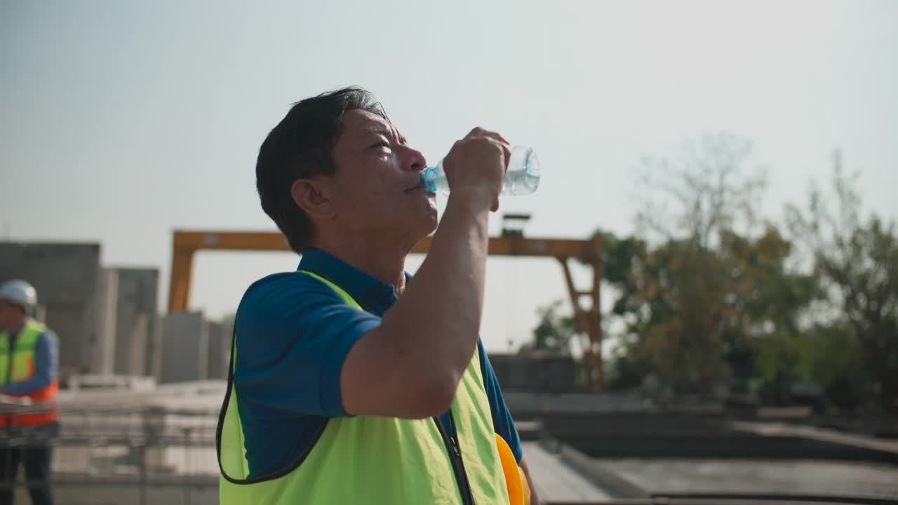 建筑工人在室外喝水的慢镜头。视频素材