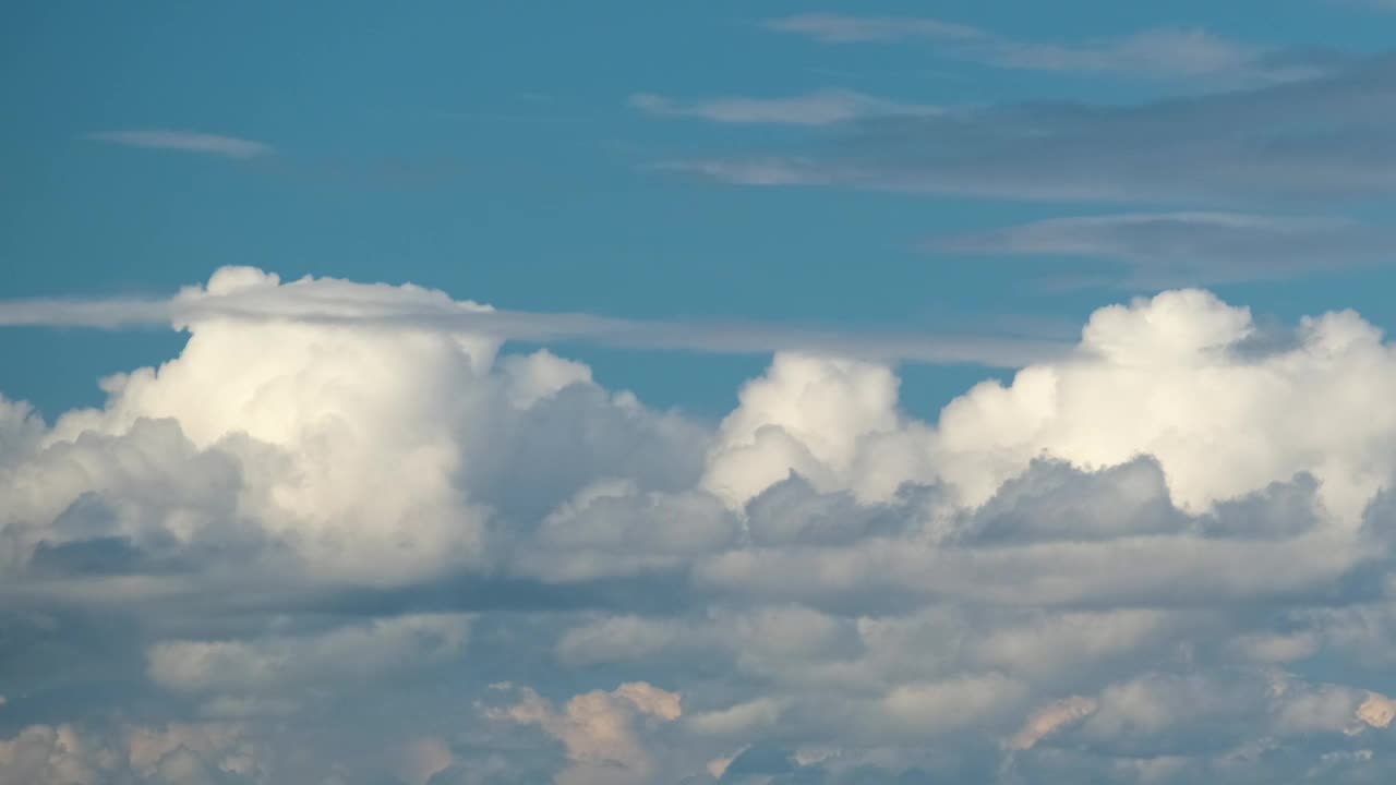 蓝色晴朗的天空上快速移动的白色蓬松积云的定时镜头视频素材