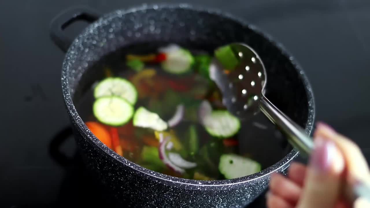 蔬菜是用砂锅煮的。蔬菜在装有热水的锅里旋转。素食主义和健康有机食品的概念视频素材