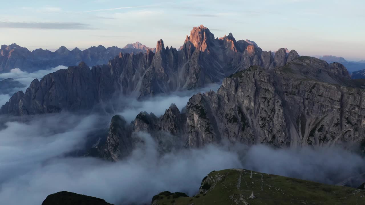 神秘的日出无人机拍摄的云层覆盖Cadini Di Misurina山脉在白云石，意大利。视频素材