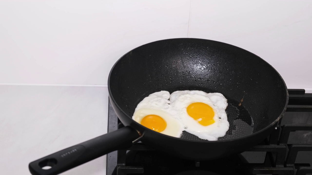 做炒鸡蛋当早餐。鸡蛋是在平底锅里煎的，这种食物富含蛋白质视频素材