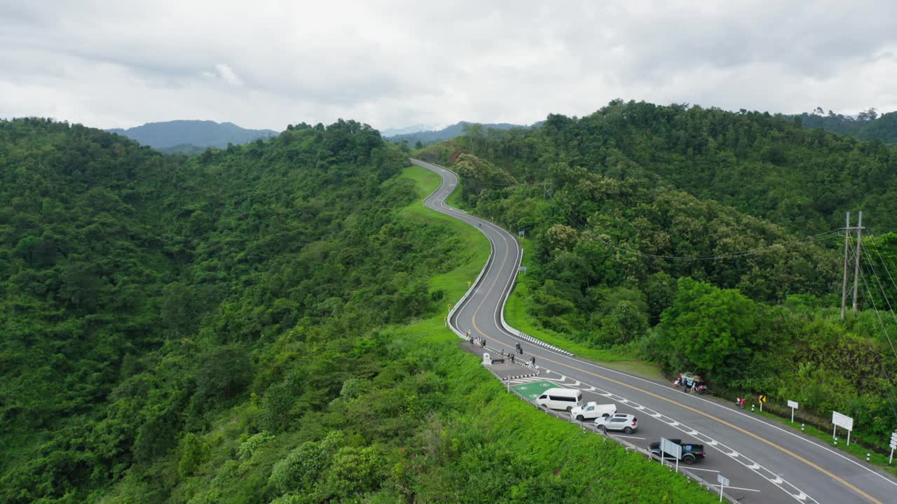 泰国南省热带雨林山区，无人机在雨季飞越蜿蜒的道路。镜头b卷，航拍的蜿蜒和危险的道路。视频素材