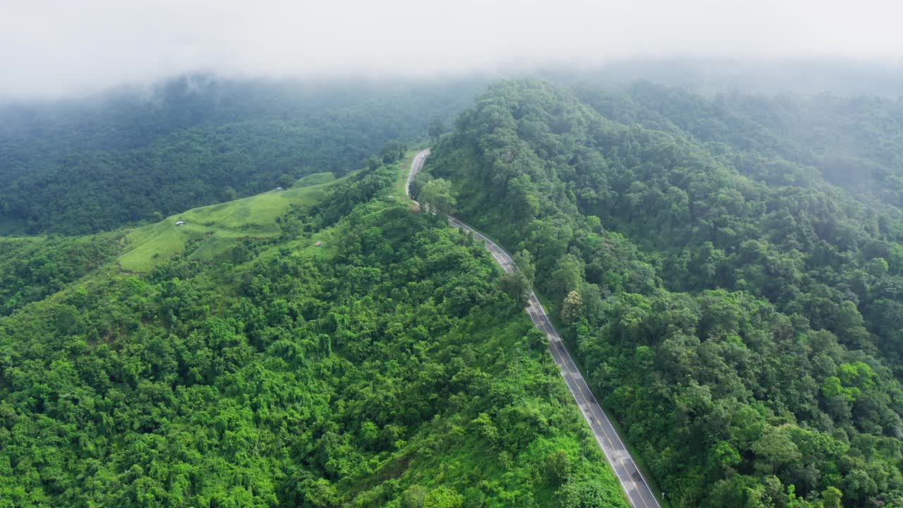 泰国南省热带雨林山区，无人机在雨季飞越蜿蜒的道路。镜头b卷，航拍的蜿蜒和危险的道路。视频素材