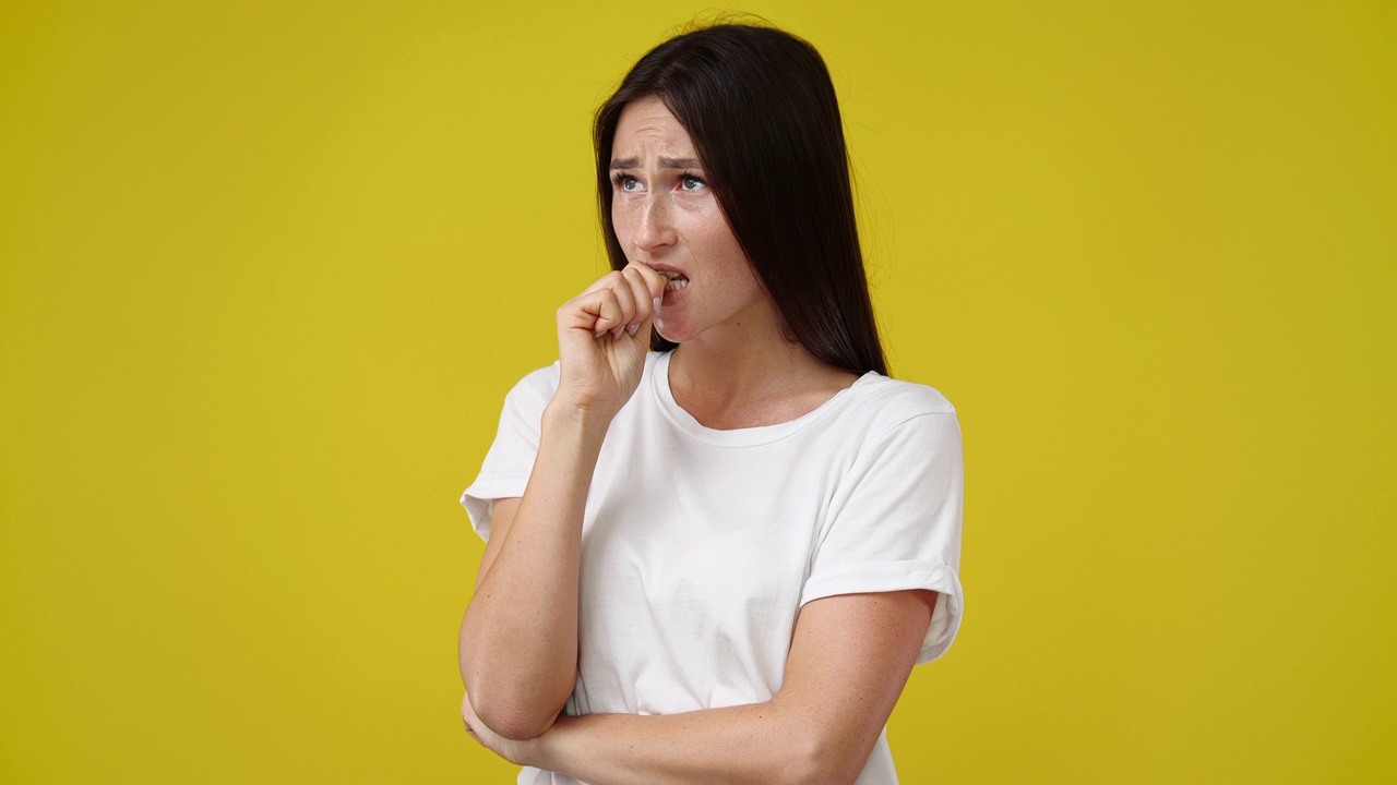 黄色背景下的女孩深思熟虑的面部表情4k视频。视频素材