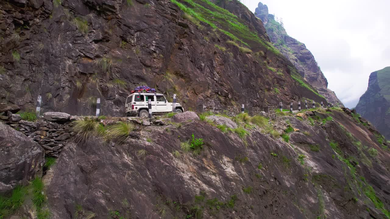 一辆空中SUV行驶在峡谷的狭窄道路上。卡利甘达基峡谷视频素材