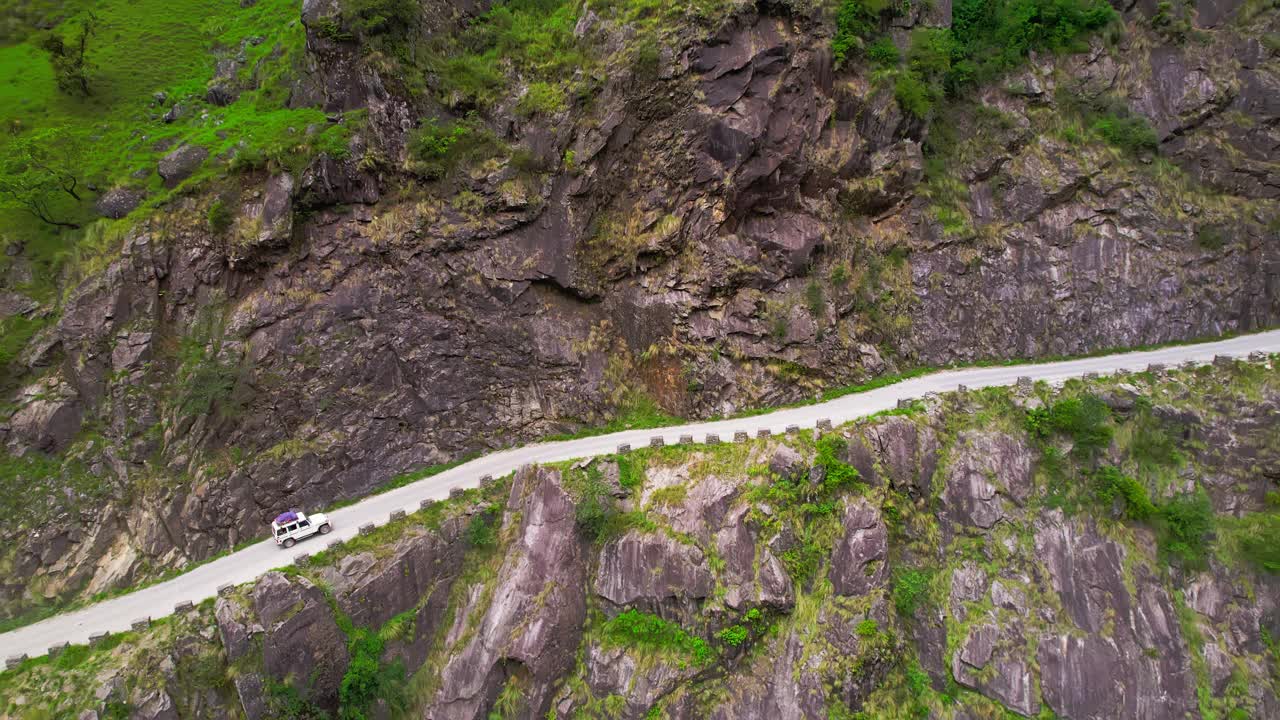 一辆空中SUV行驶在沿着峡谷的狭窄道路上视频素材