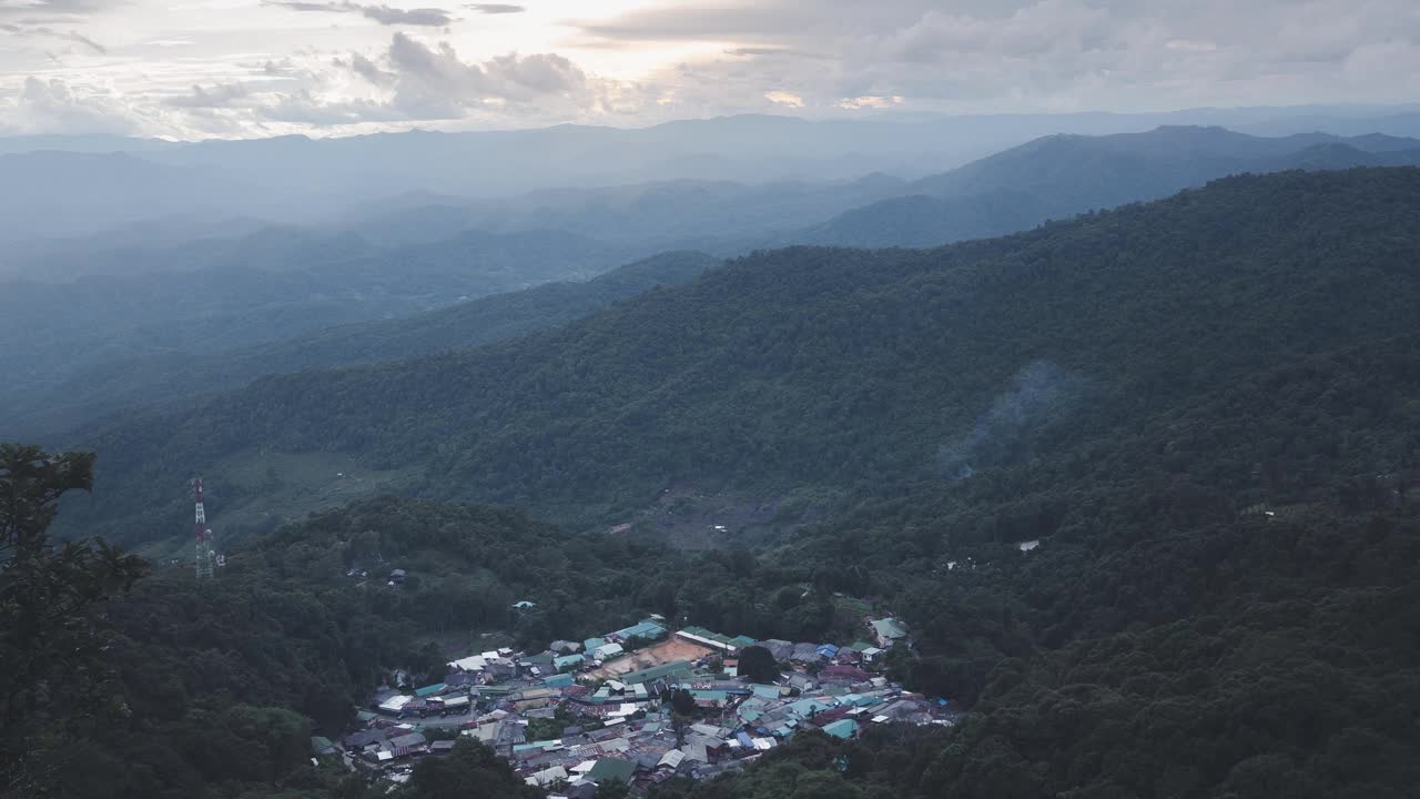 随着时间推移，雾和烟在山谷中的一个小村庄上空飘过。天空，山，小山，放大。视频素材