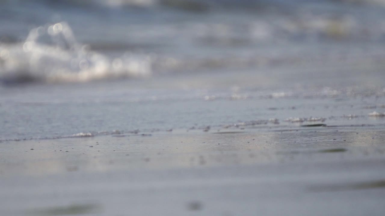 特写海浪溅湿海滩沙子干燥，电影dof视频素材