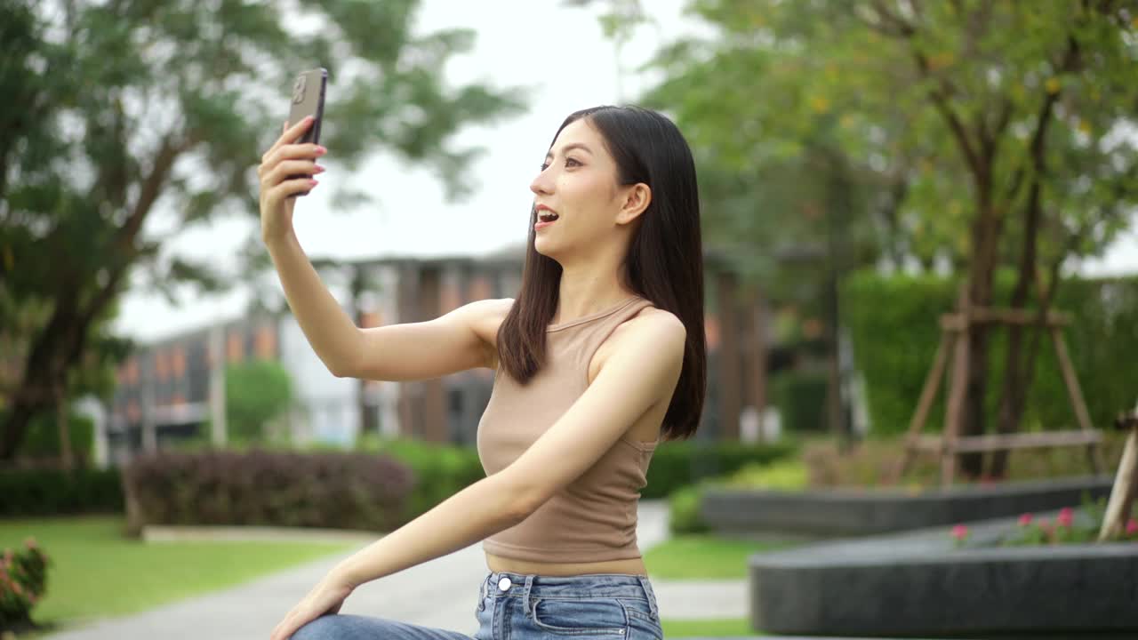 快乐的感觉，美丽的年轻女子视频电话看着相机。博主喜欢在线对话。视频博主或有影响力的女性手持智能手机自拍，对着相机拍摄视频博客。视频素材