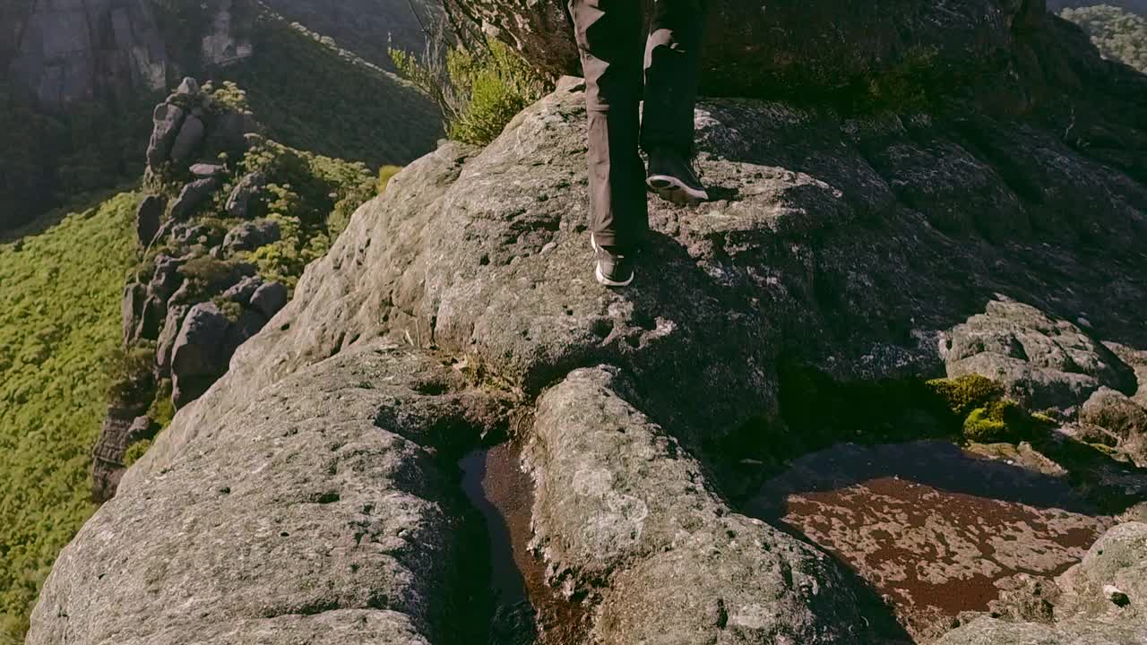 年轻男子在背包旅行时在山的边缘拍摄风景照片视频素材