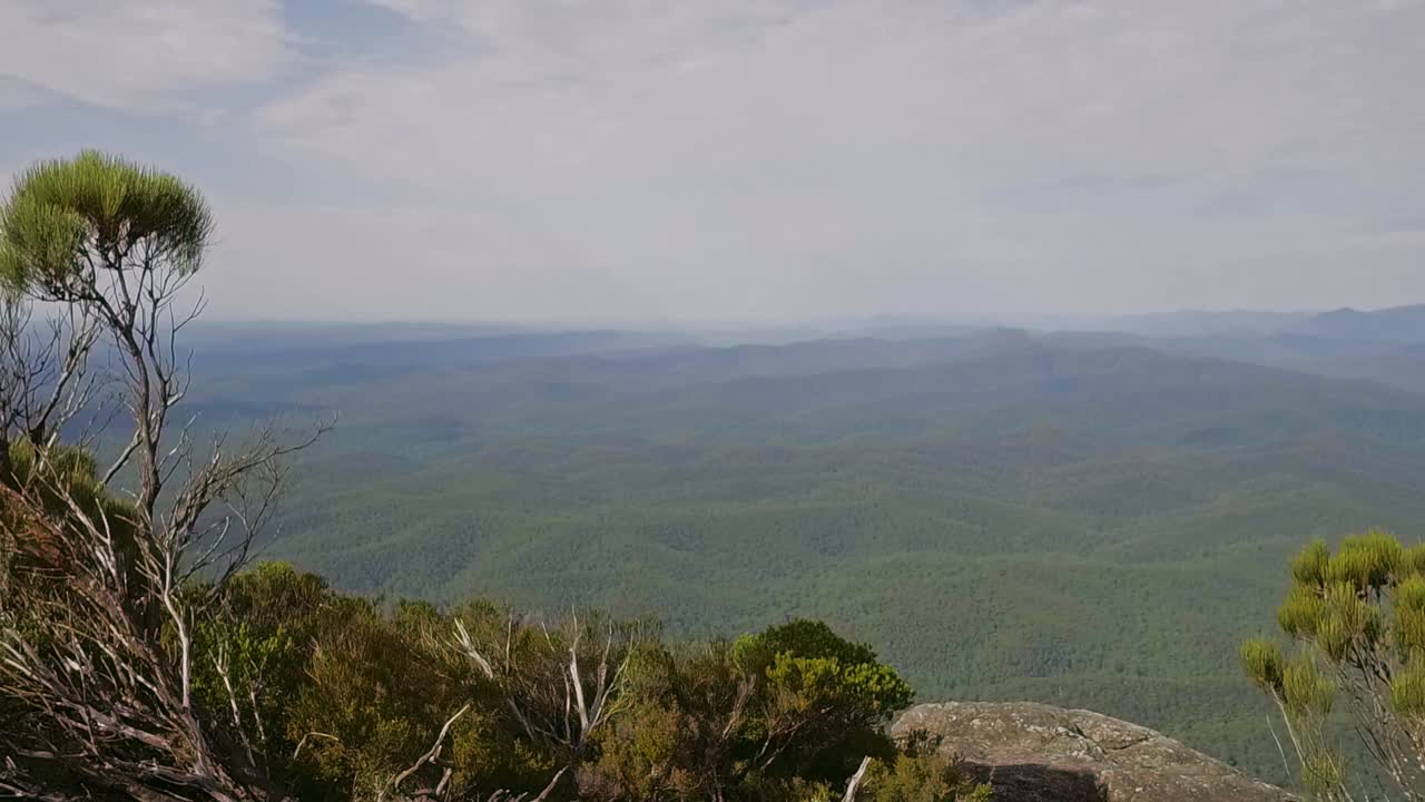 年轻男子在背包旅行时在山的边缘拍摄自然景色的照片视频素材