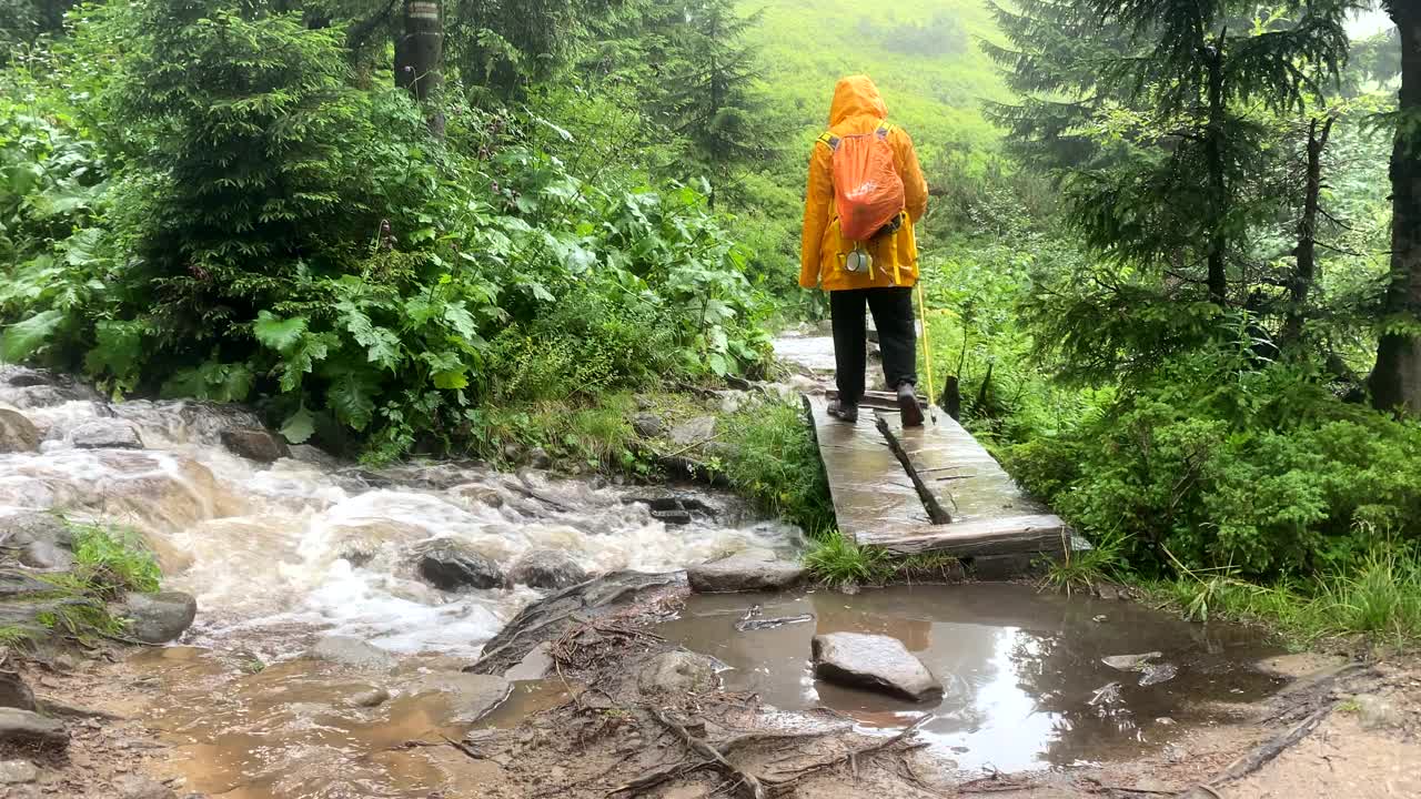 穿黄雨衣的女人过山溪视频素材