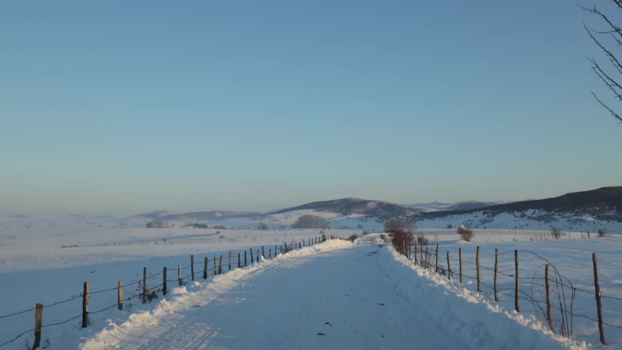 在塞尔维亚大雪纷飞的乡村路上开车视频素材